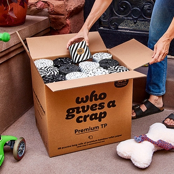 Someone reaching into a box of TP from who gives a crap