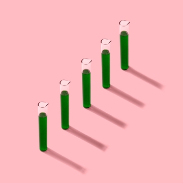 Colored vials lined up against a pink background