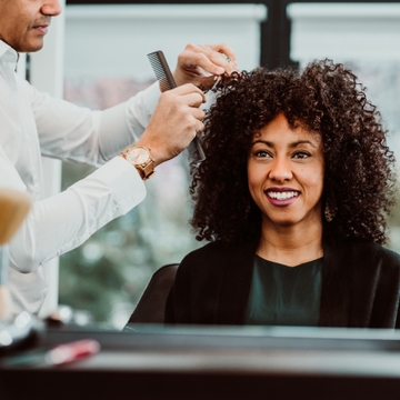 Smiling woman getting her curly hair done