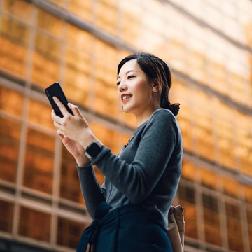 woman on phone in front of building