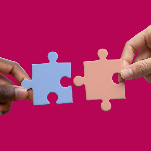 two puzzle pieces are connected, symbolizing teamwork and collaboration